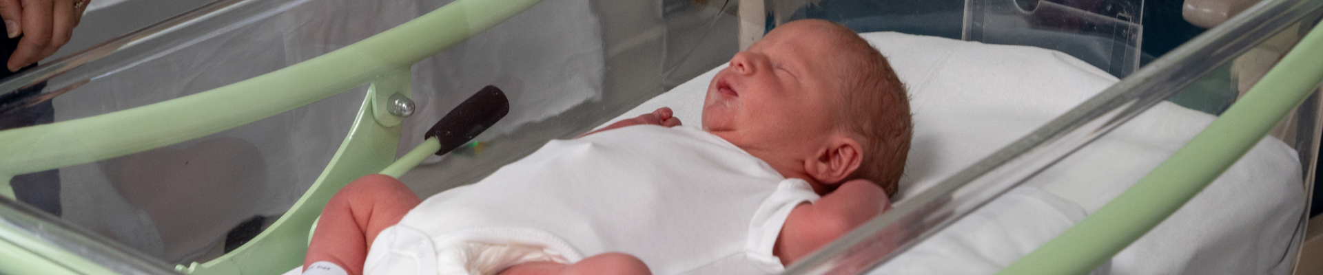 Baby in cot on maternity ward