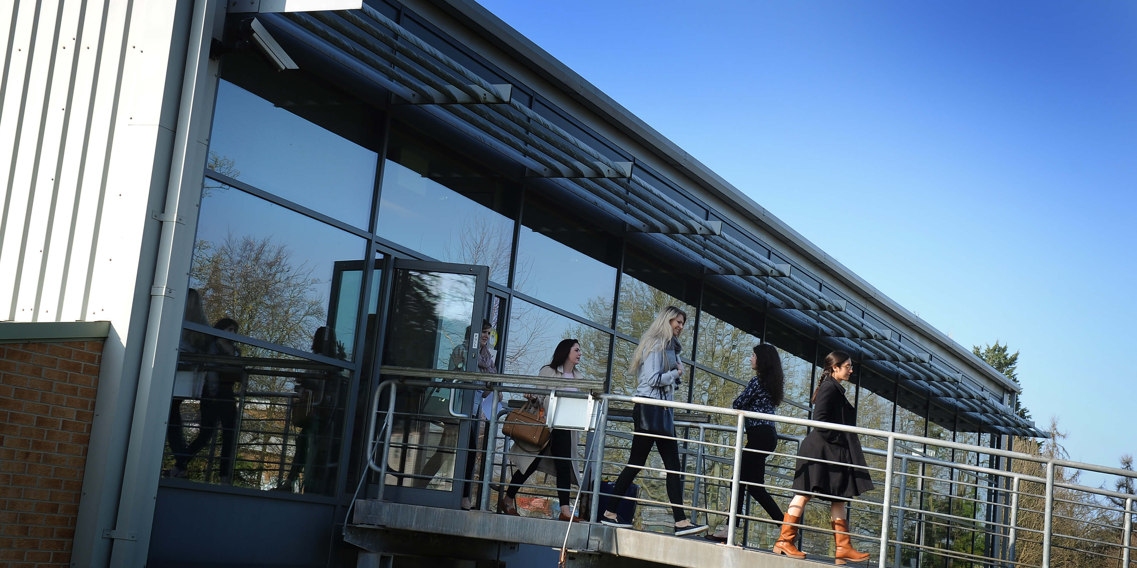 People walking over the bridge outside the education centre