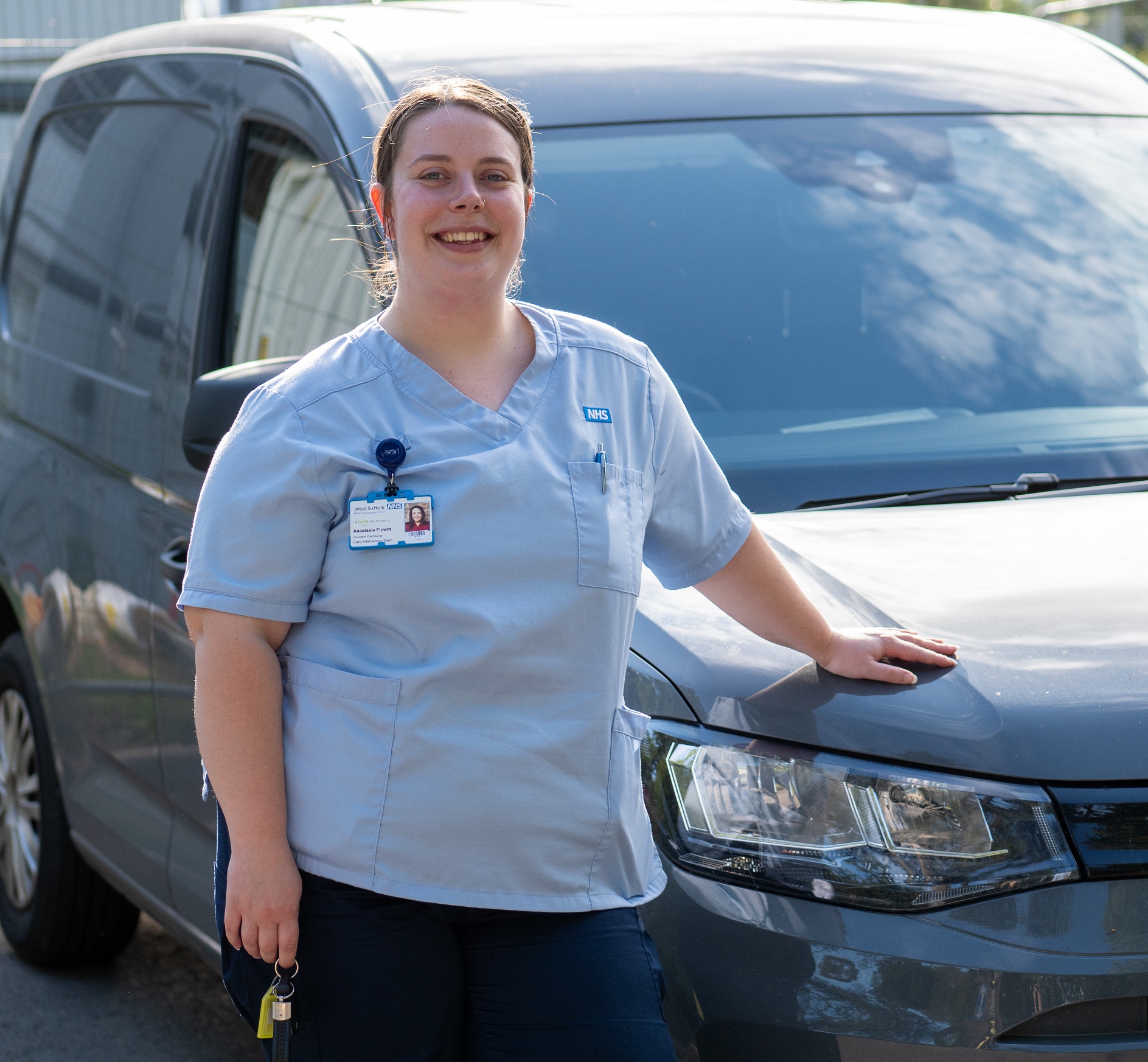 EIT colleague standing next to a car