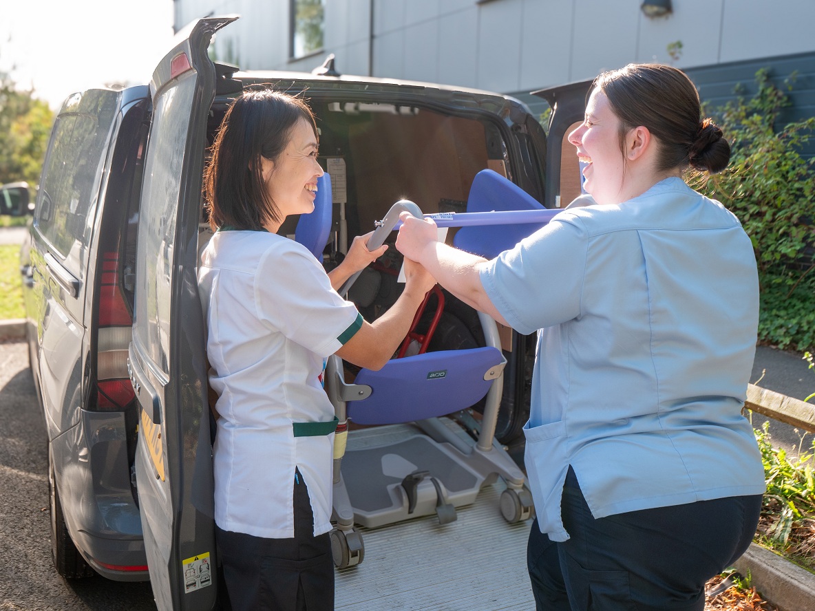 Two EIT colleagues loading a wheelchair in a van