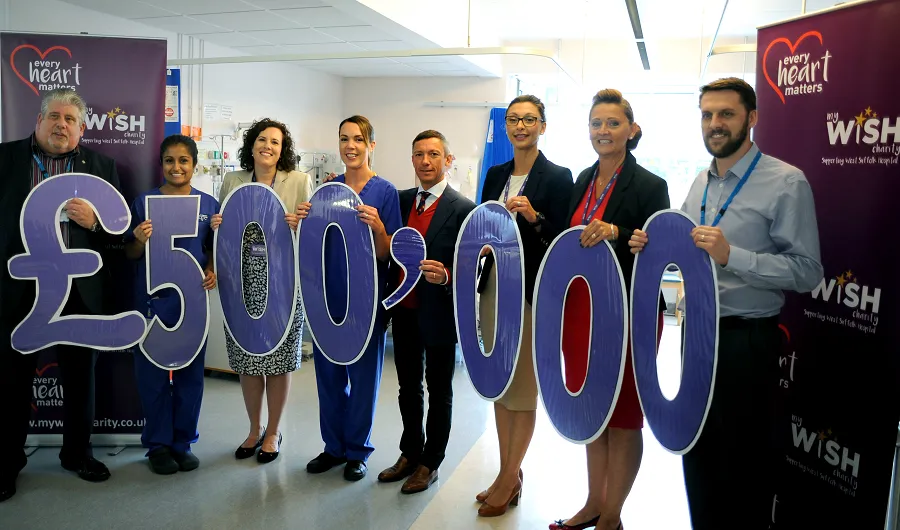 Members of staff and My WiSH Charity team holding up '£500,000'