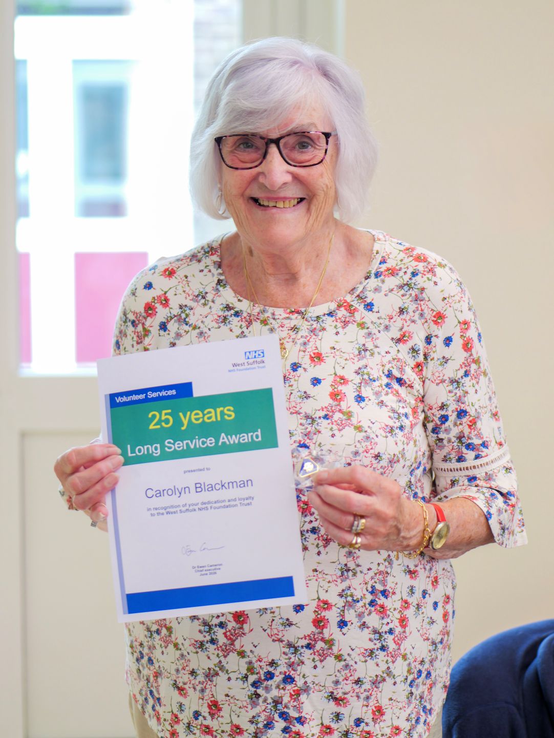 carolyn blackman holding up her certificate and smiling