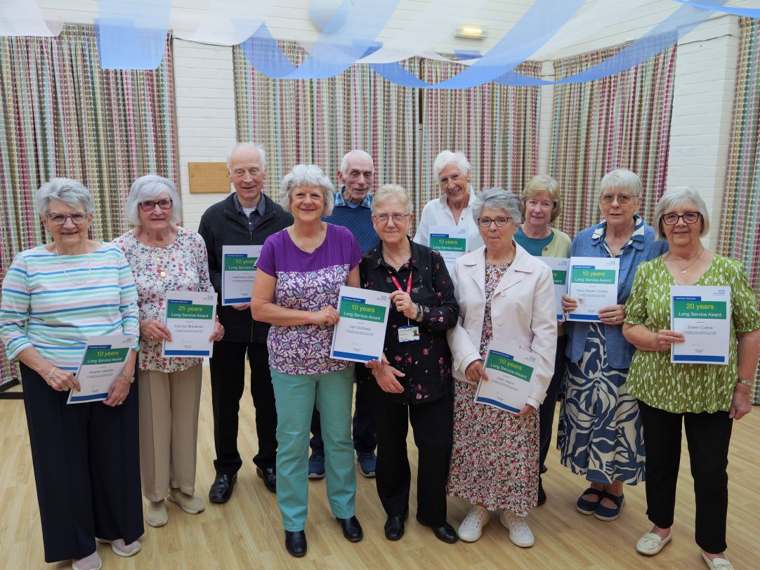 All the long service award winners smiling and holding up their certificates