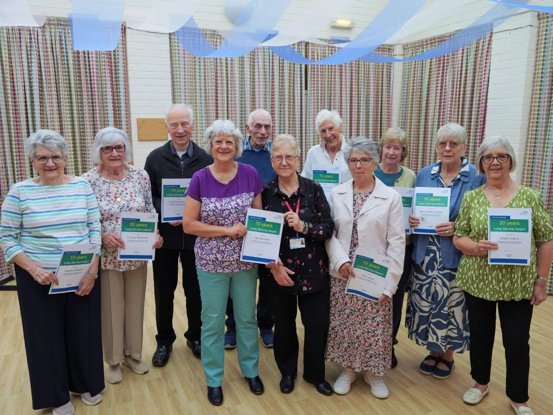 All the long service award winners smiling and holding up their certificates