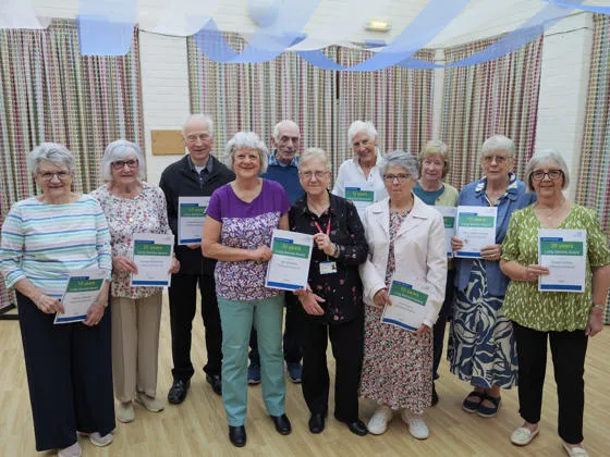 Long service award winners standing together and holding up their certificates