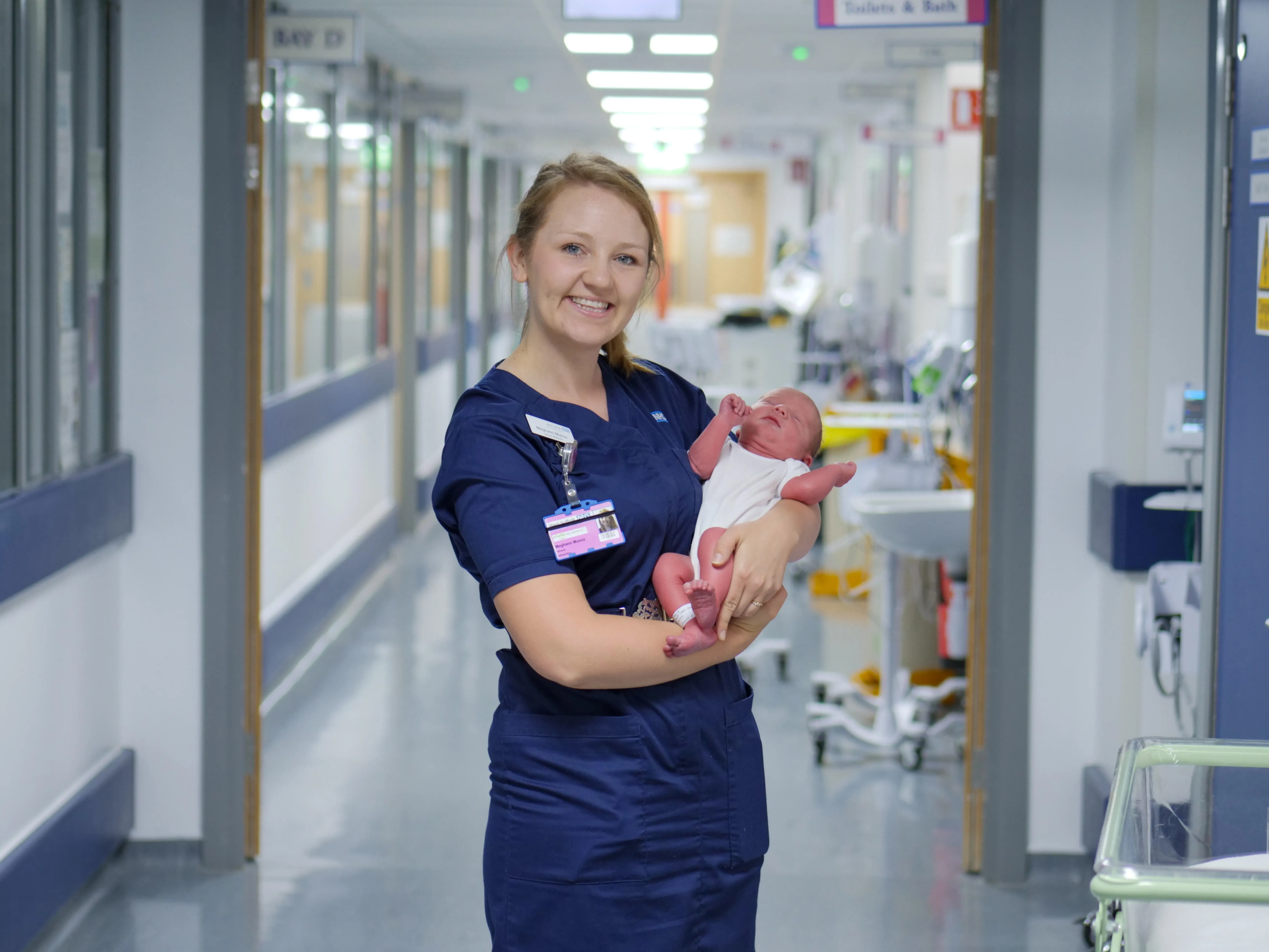 Midwife holding a baby on a maternity ward