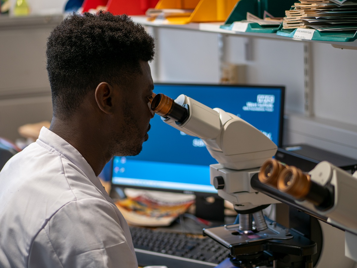 Pathology colleague looking into microscope
