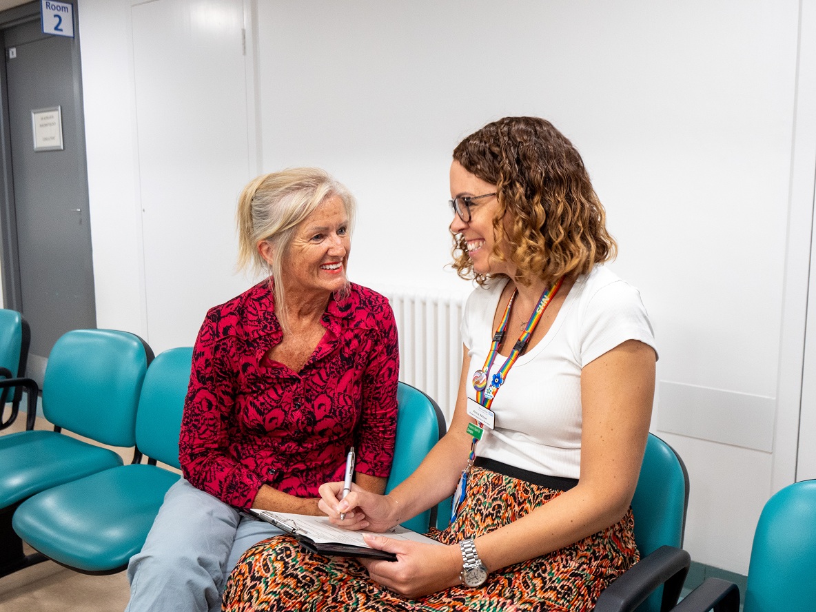 Two people chatting and smiling in a waiting room