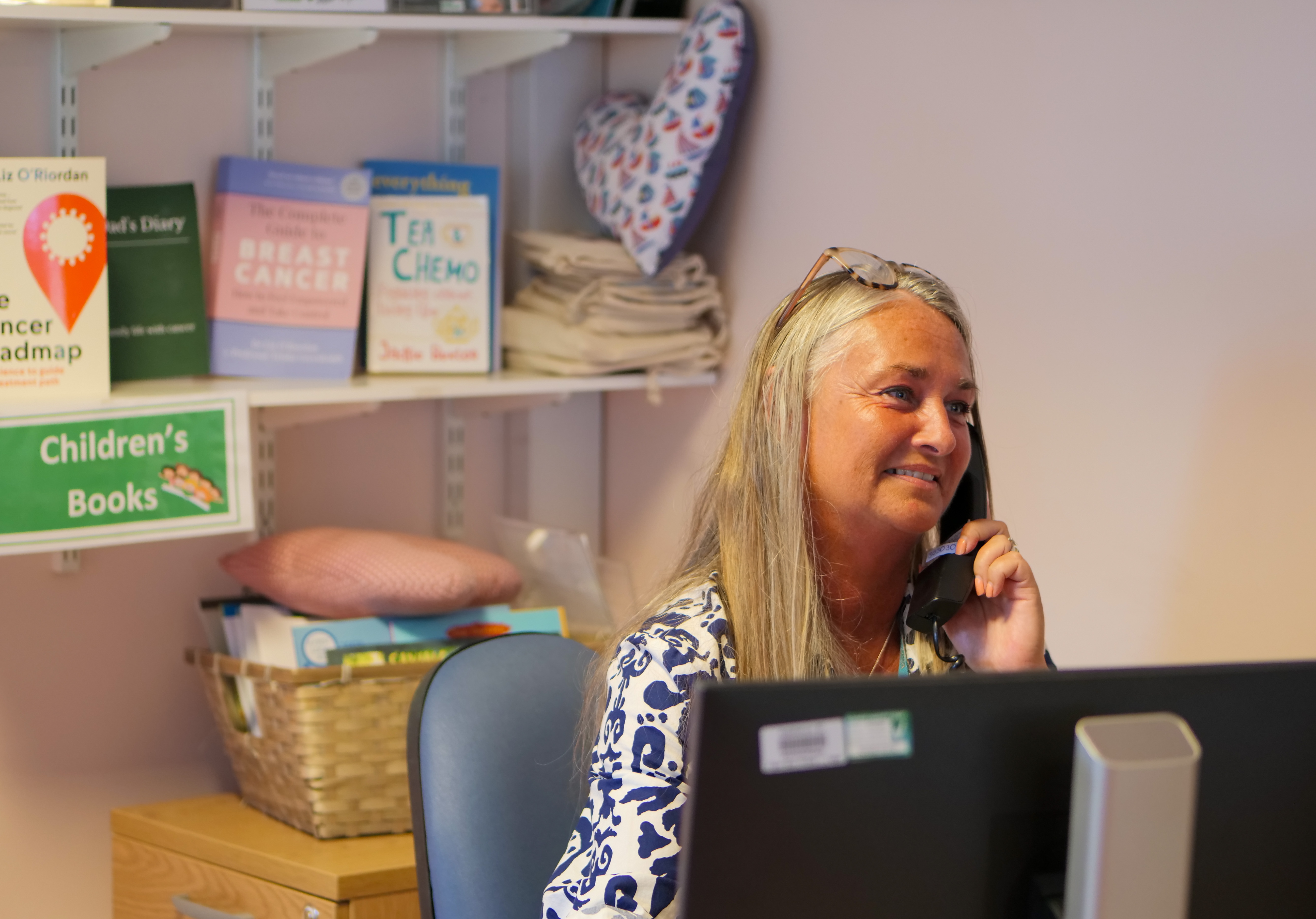 Staff member in the Macmillan Information Centre speaking on the phone at her desk