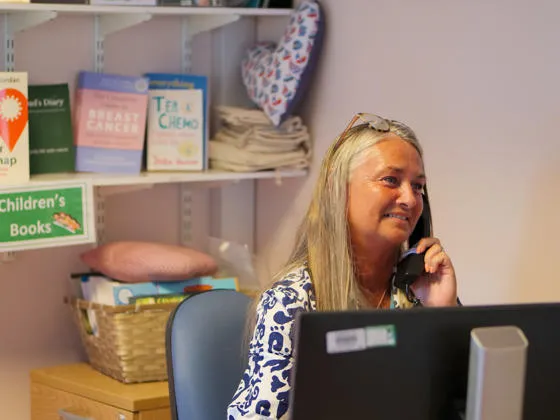 Staff member in the Macmillan Information Centre speaking on the phone at her desk