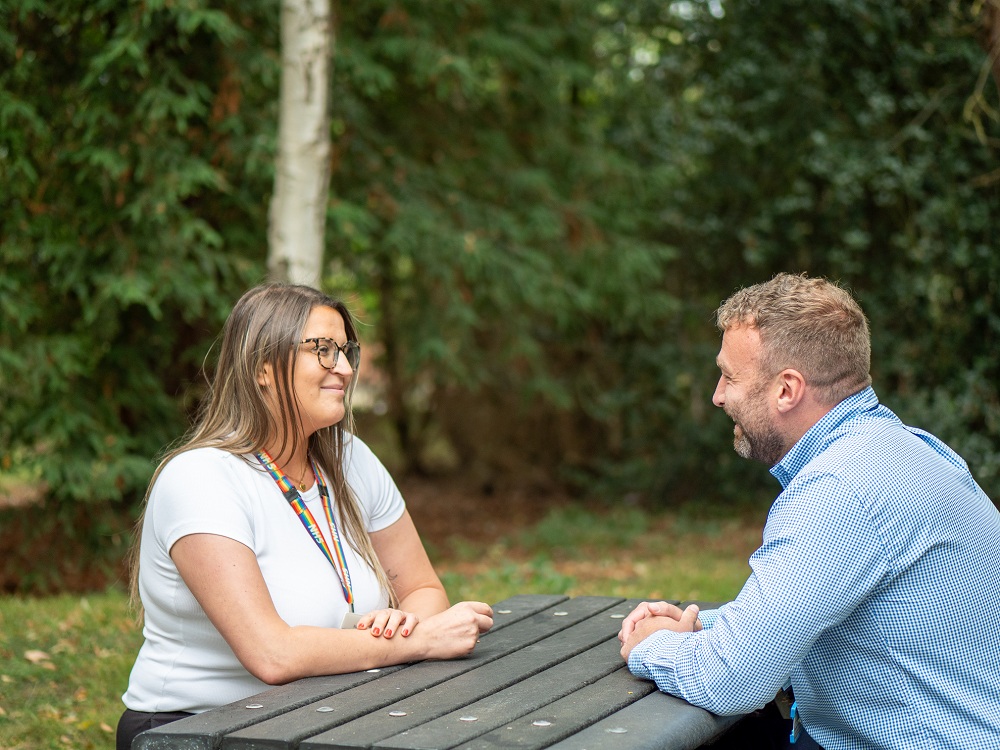 Two colleagues sitting on a bench and chatting