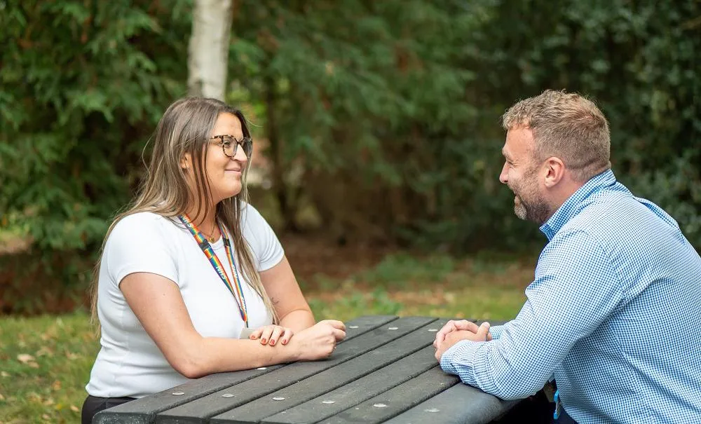 Two colleagues sitting on a bench and chatting