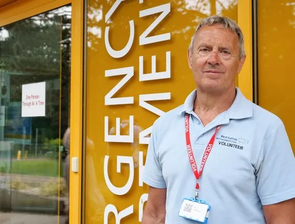 Volunteer standing outside the Emergency Department entrance