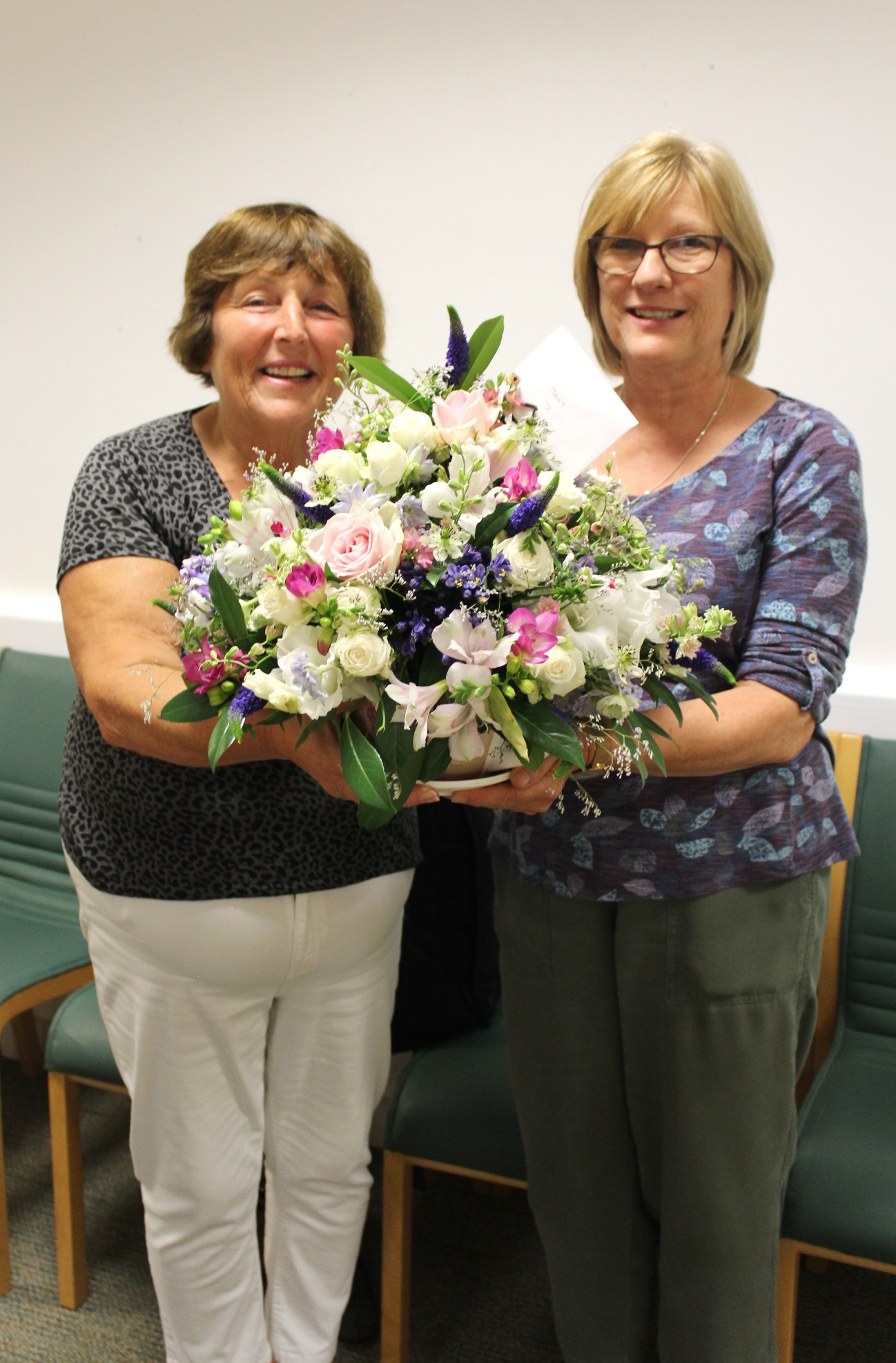 Jeanette Gammon, left, Trust volunteer and former critical care patient, presenting Janet Thomas, critical care follow-up sister, with her retirement flowers from former critical care patients