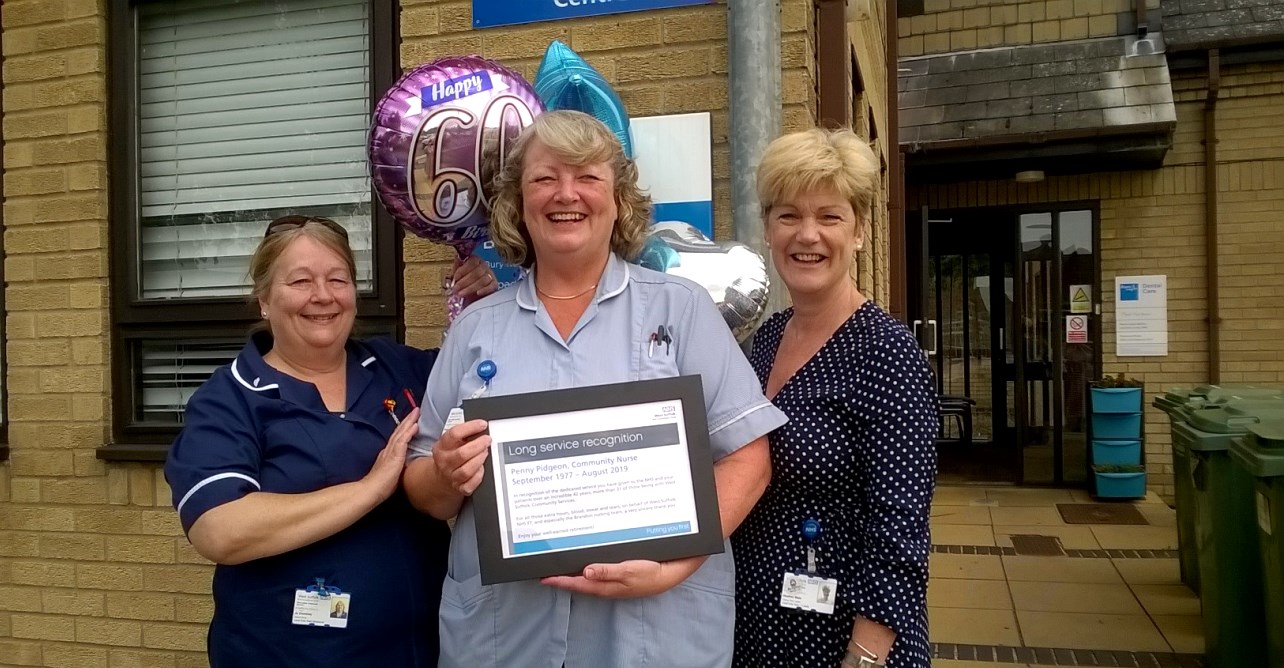 District nursing sister Jo Dominey (left) and team lead Heather Male present Penny Pidgeon (centre) with her long service certificate.